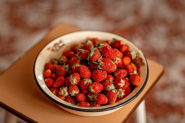 a Cup of strawberries on a stool on the background of the carpet
