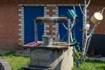 well and birch branches with pots in the yard of a rural house in Chuvashia in Russia