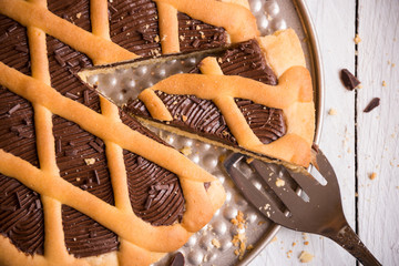 Delicious homemade chocolate cake on white wooden background
