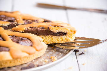 Delicious homemade chocolate cake on white wooden background