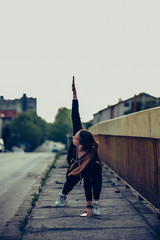 Young woman doing some stretching exercises on the bridge,