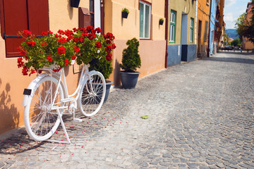 Fototapeta na wymiar Ornamental bicycle with flowers on it on the streets of downtown Sibiu in Romania