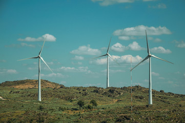Several wind turbines over hilly landscape