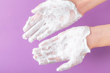 The hands of a teenager are treated with white cream