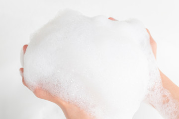 A lot of foam in the hands of a man in the bathroom