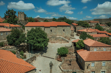 Stone houses and chapel encircling a square with pillory