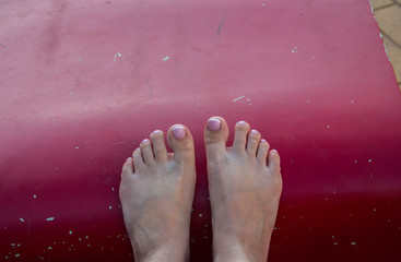 a beautiful pedicure and female feet on a red background