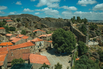 Fototapeta na wymiar Rooftops of stone houses with square and large wall