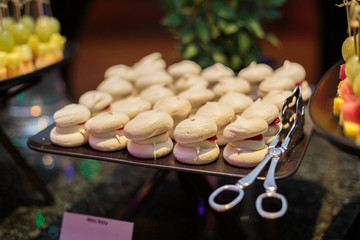 Plate with white meringues at the party