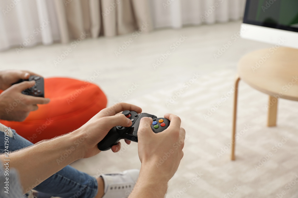 Wall mural Friends playing video games at home, closeup view