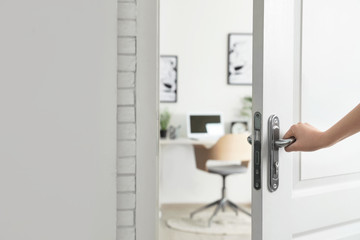 Woman opening door to stylish room, closeup. Interior design