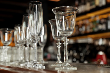 Different empty clean glasses on counter in bar
