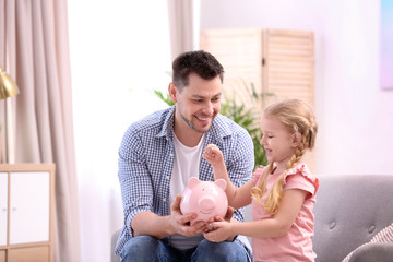 Family with piggy bank and money at home