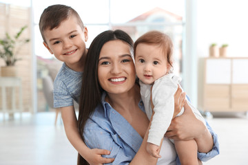 Happy mother with her cute children at home. Family time