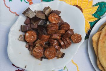 various homemade sausages and bacon served on a plate