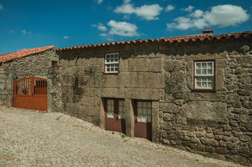 Fototapeta na wymiar House made of stone with wooden door and deserted alley