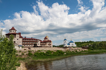 Fototapeta premium terrain, landscape, monastery, territory, architecture, style, buildings, Church, blue, sky, white, clouds, river, water, shore, beauty