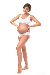 Fototapeta premium Young and beautiful pregnant woman on white background