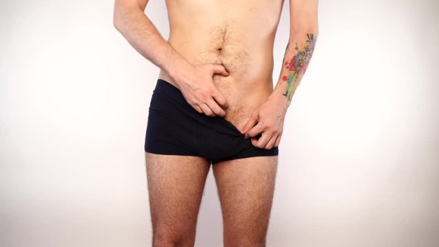 Man scratching crotch on white background, closeup. Annoying itch