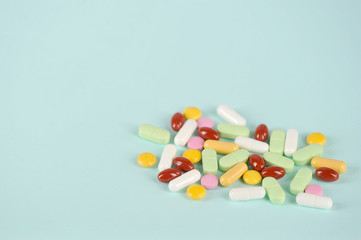 Medications or drugs in the form of tablets, of various sizes, shapes and colors. Tablets for oral administration on a light background. Free space to place text.