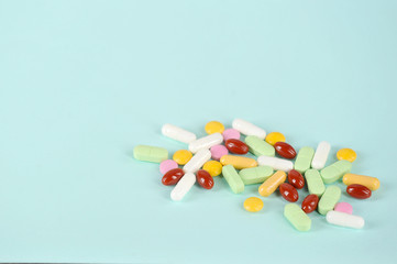 Medications or drugs in the form of tablets, of various sizes, shapes and colors. Tablets for oral administration on a light background. Free space to place text.