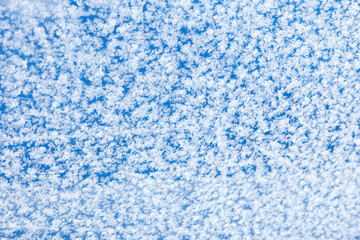 Patterns of natural hoarfrost on glass on a blue background. winter frost background, texture