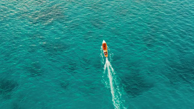 Motor boat on the surface of the lagoon with turquoise water, top view. Summer and travel vacation concept. Balabac, Palawan, Philippines.