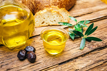 Organic, natural and healthy cold pressed olive oil on wooden table. Virgin italian or spanish olive oil in a bowl for healthy vegetarian or vegan breakfast close up concept image.