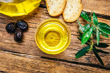 Organic, natural and healthy cold pressed olive oil on wooden table. Virgin italian or spanish olive oil in a bowl for healthy vegetarian or vegan breakfast close up concept image.