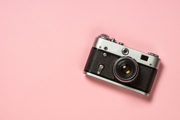 Old film camera on pink background.