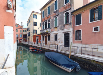 Fototapeta na wymiar Quiet channel with boat in Venice