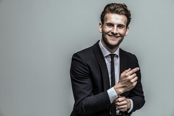 Portrait of a smiling handsome model in a classic black and white style clothing. Studio shot. Copy space.