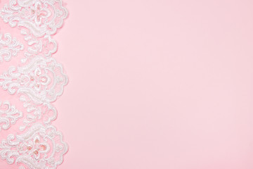 Beautiful white floral lace on a pink background.