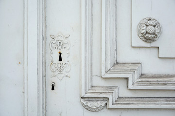 Fragment of a wooden carved door painted with white paint. Architectural background with empty space