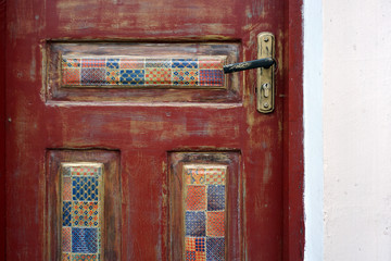 A fragment of a wooden door with patterned decoupage inserts