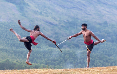 Indian fighters performing Weapon Combat during Kalaripayattu Marital art demonstration in Kerala, India