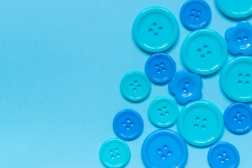 Various blue sewing buttons on blue background