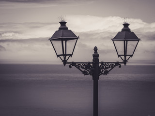 stylistic street lanterns with sea and clouds in the background