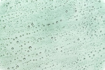 In selective focus many droplets on car mirror on green color background 