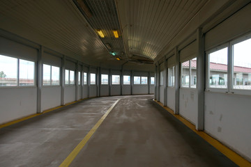 deserted indoor pedestrian crossing lit by lamps and light from the windows