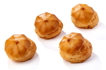 Profiterole or eclair, homemade sweets, close-up, isolated on white background.
