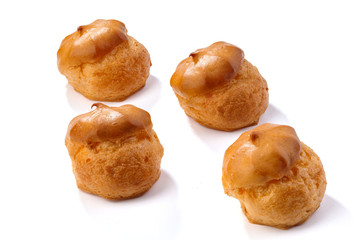 Profiterole or eclair, homemade sweets, close-up, isolated on white background.
