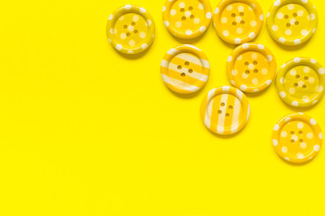 Fototapeta premium Various yellow sewing buttons on yellow background