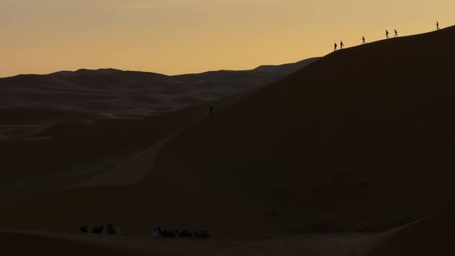 Sunrise over Erg Chebbi desert with tourists