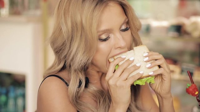 Close-up Mouth Of Adorable Hungry Woman Eating Appetizing Sandwich Enjoying Food. Face Of Pleasant Young Woman Having Meal Tasty Fast Food Snack Feeling Positive Emotion