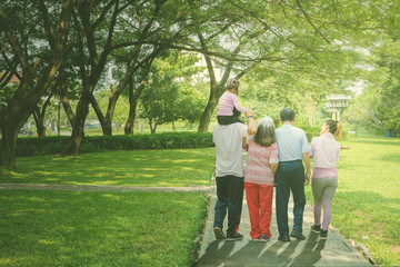 Fototapeta premium Multi generation family walks in the park