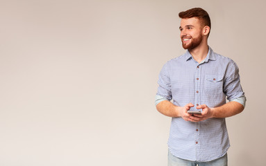 Young man blogger using his phone and looking away