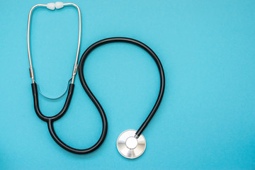 Medical stethoscope isolated on blue background top view. Health care concept.