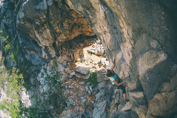 A girl climbs a rock.