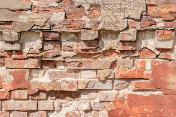 abstract background of an old brick wall with peeling plaster close up